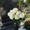 Білі троянди у вазу на кладовище
