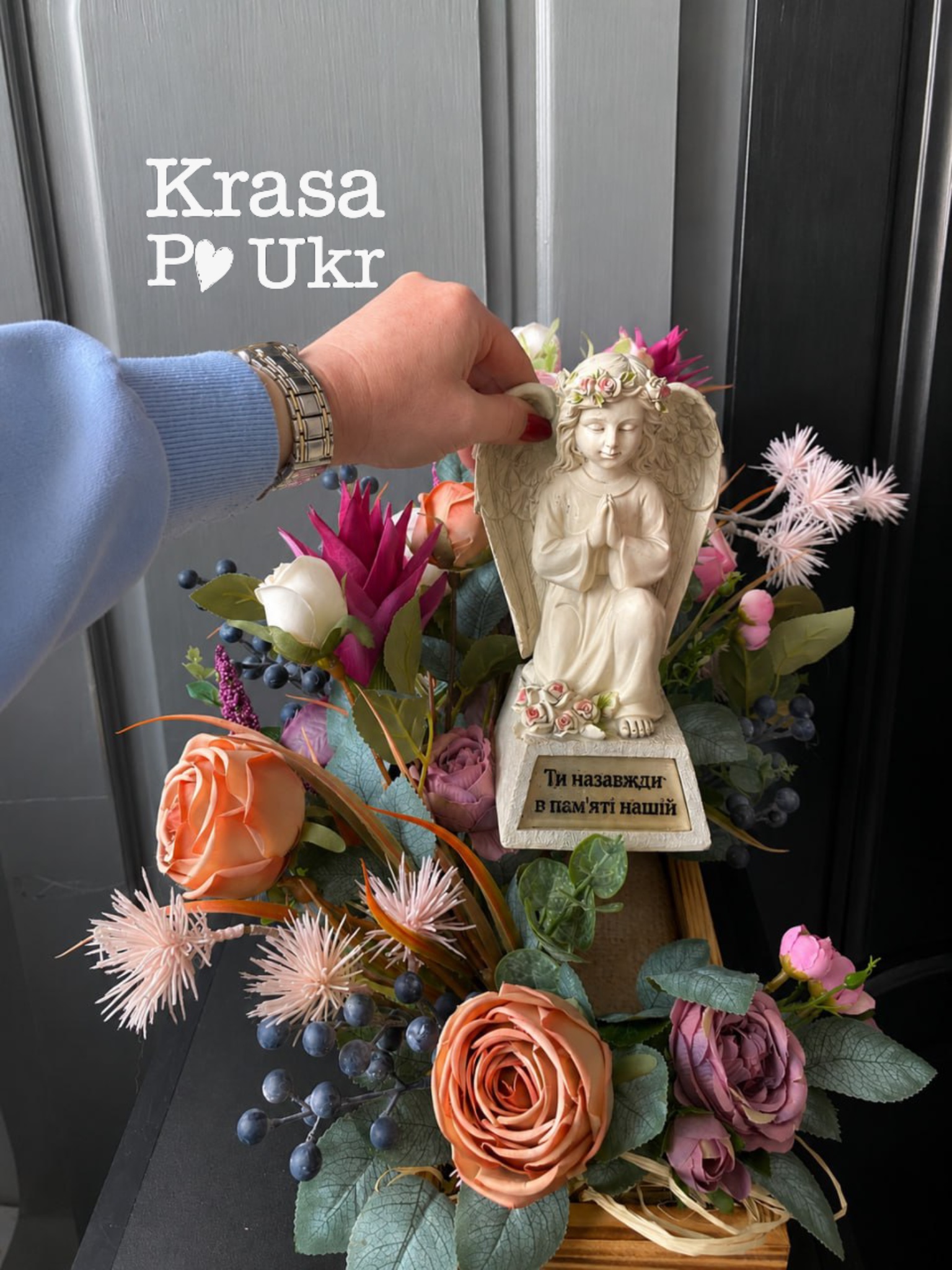 Статуетка лед ангела в меморіальному декорі з квітів