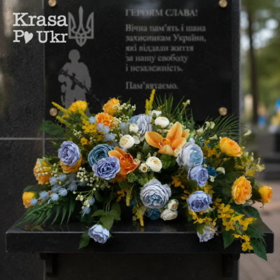Композиція зі штучних квітів на поличку пам’ятника Герою